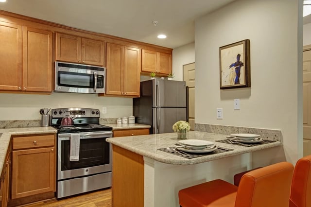 Modern kitchen with stainless steel appliances and granite countertops.