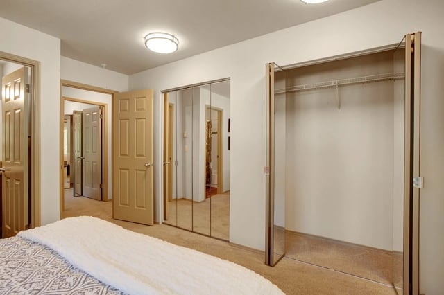 Bedroom with mirrored closet doors and multiple interior doors.
