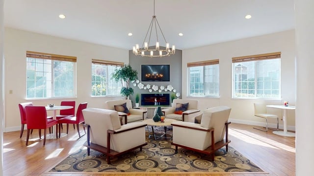 Cozy resident lounge area with comfortable seating, a fireplace, and a television.