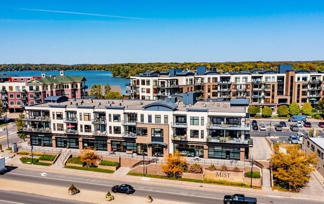 Exterior view of The Mist apartment building with a lake in the background.