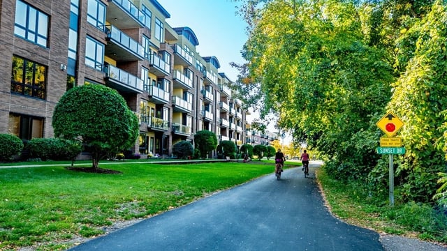 Apartment building exterior with manicured lawn and paved bike path