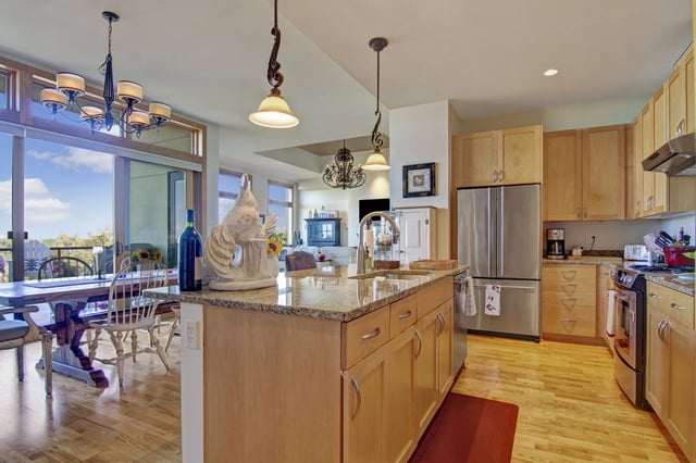 Modern kitchen with granite countertops, stainless steel appliances, and a dining area.