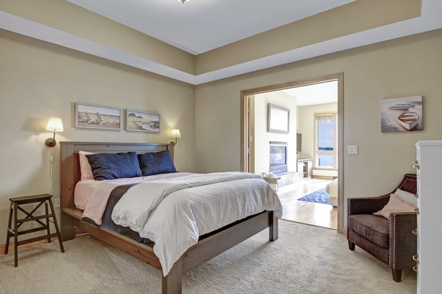 Bedroom with king size bed, fireplace and water view