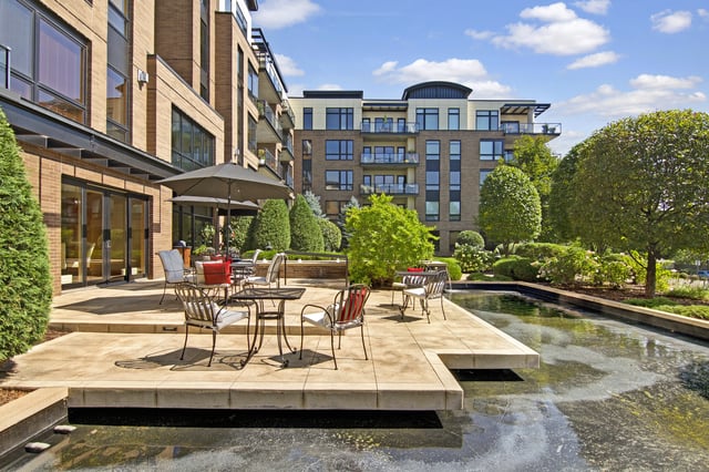 Modern apartment building with an outdoor patio and water feature.