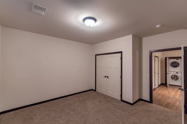 Bedroom with closet and in-unit washer and dryer visible