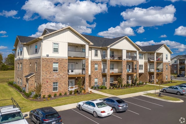 Exterior of a modern apartment building with brick accents and balconies.