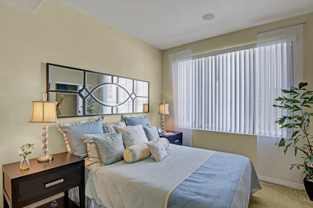 Bedroom with a king-size bed, nightstands, and a large mirror.
