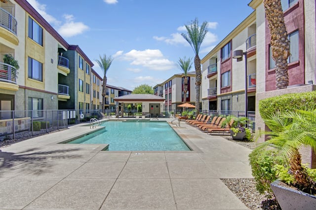 Outdoor swimming pool with lounge chairs and a covered cabana.