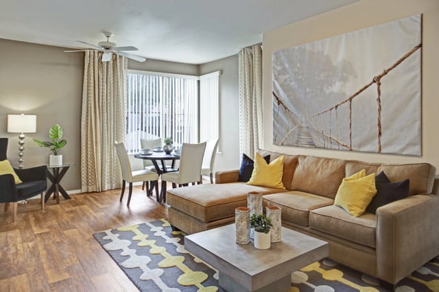 Living room and dining area with a sectional sofa, coffee table, and dining set.