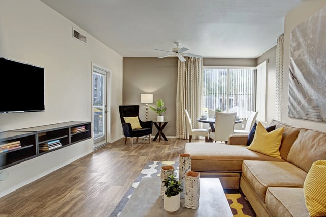 Living and dining area with a sectional sofa, TV, and dining table.
