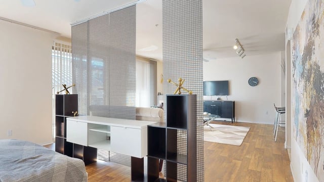 Modern living room and bedroom separation with stylish furniture.