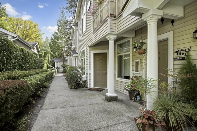 Exterior view of apartments with a walkway and landscaping.
