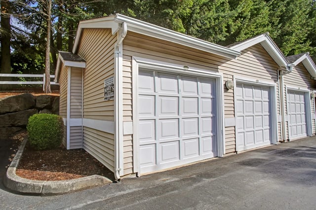Garages with white doors and beige siding.