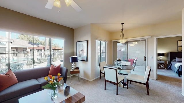Living room and dining area with a view of the pool and a glimpse of the bedroom.