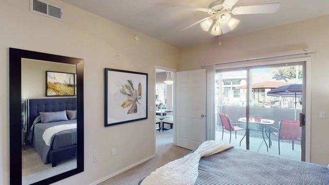 Bedroom with a king-size bed, ceiling fan, and patio access.