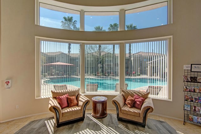 Comfortable seating area with chairs and a table overlooking the pool.