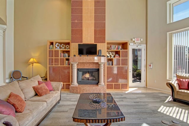 Living area with fireplace, built-in shelving, and comfortable seating.