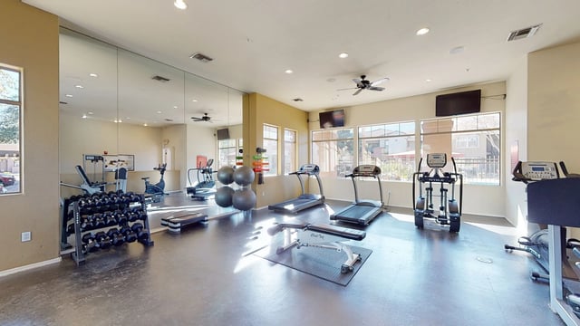 Fitness center with treadmills, ellipticals, free weights, and weight machines.