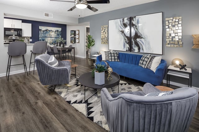 Living room and dining area with blue sofa, gray chairs, and dining table.