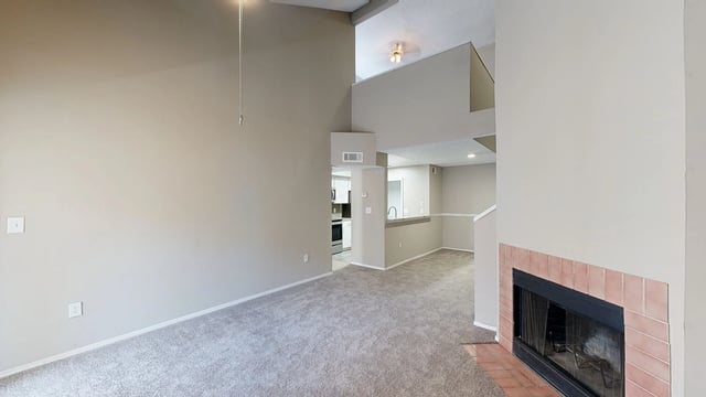 Spacious living room with vaulted ceilings and a fireplace.