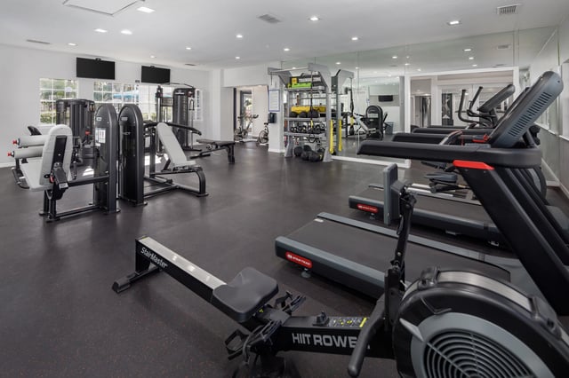 Fitness center with treadmills, rowing machines, weight machines, and a free weight area.
