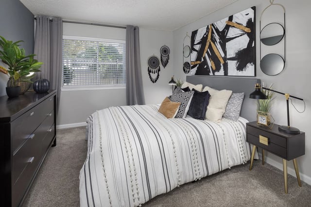 Primary bedroom with a queen-size bed, dresser, and nightstand.