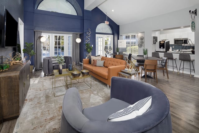 Clubhouse lounge area with seating, tables, and a small kitchen.