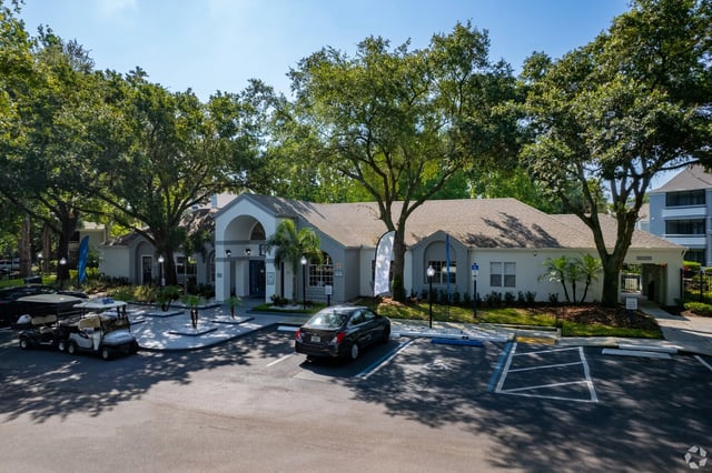 Clubhouse entrance with parking lot and golf carts