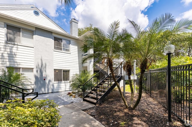 Exterior building view with stairs and palm trees.