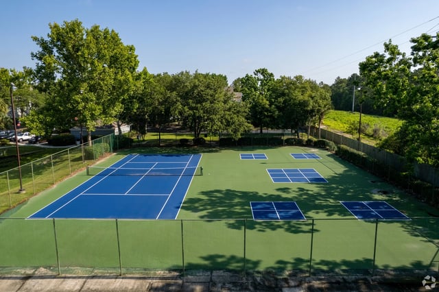 Tennis and pickleball courts surrounded by trees