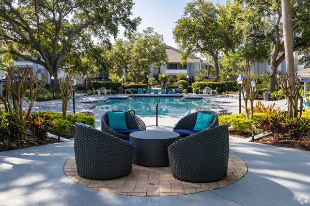 Outdoor swimming pool with lounge chairs and seating areas at a multifamily property.