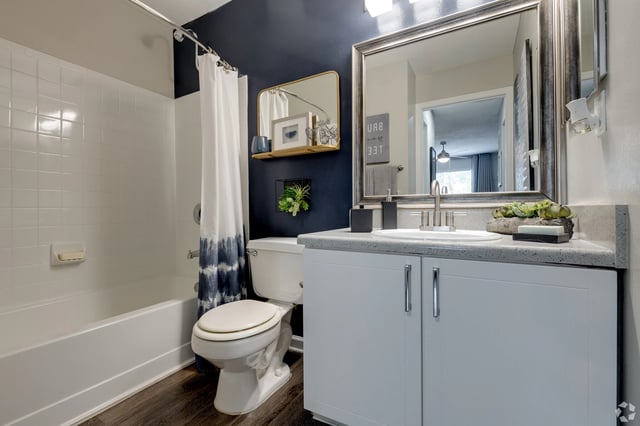Modern bathroom with a soaking tub, vanity with a sink, and toilet.
