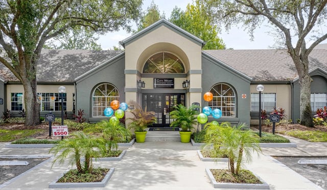 City West Apartment Homes leasing center entrance with balloons and landscaping.