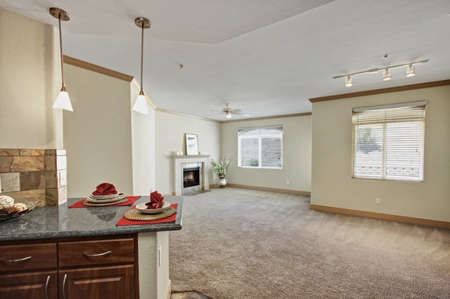 Living room and kitchen area with a fireplace and island counter.