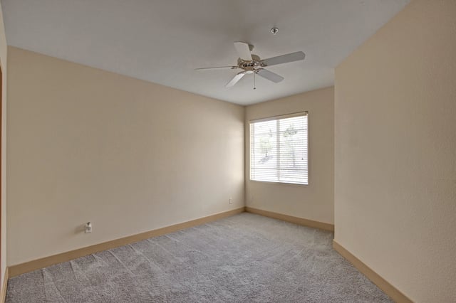 Empty bedroom with ceiling fan and window.