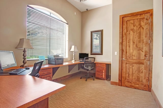 Business center with computers, printer, and desk space.