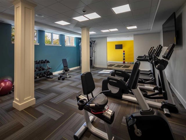 Interior view of a well-equipped fitness center with cardio machines and free weights.