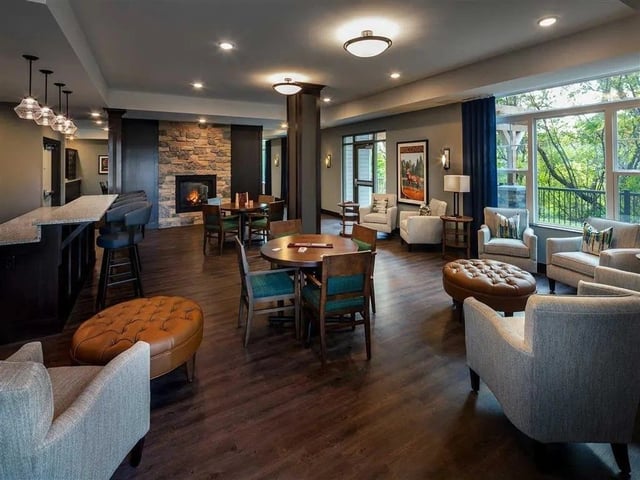 Community lounge area with fireplace, bar seating, and comfortable chairs.