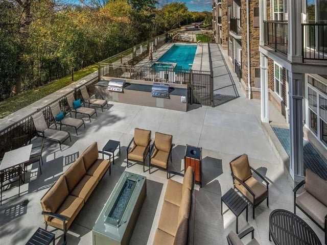 Outdoor lounge area with pool and grills