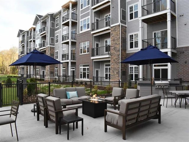 Exterior courtyard with seating, fire pit, and grill area.