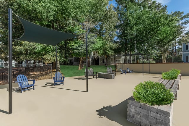 Outdoor seating area with Adirondack chairs, benches, and a fire pit.