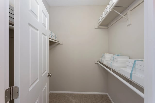 Interior of a walk-in closet with shelves and stacked boxes.