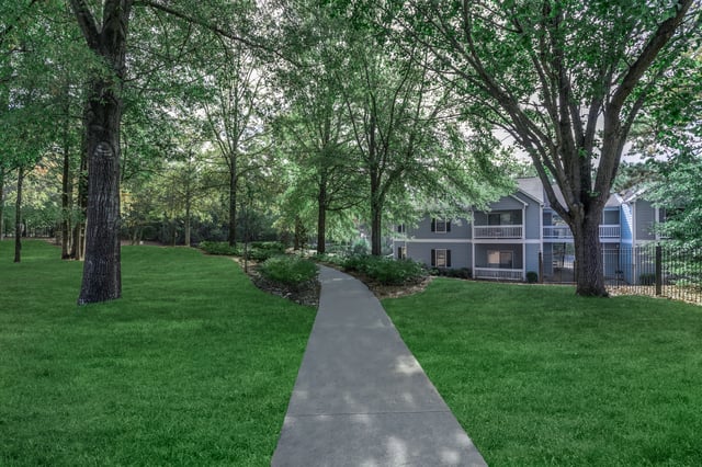 Pathway through green lawn leading to apartment buildings