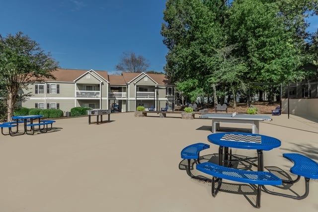 Outdoor community space with picnic tables, foosball, and ping pong.