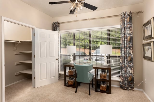 Home office with a desk, chair, and closet.