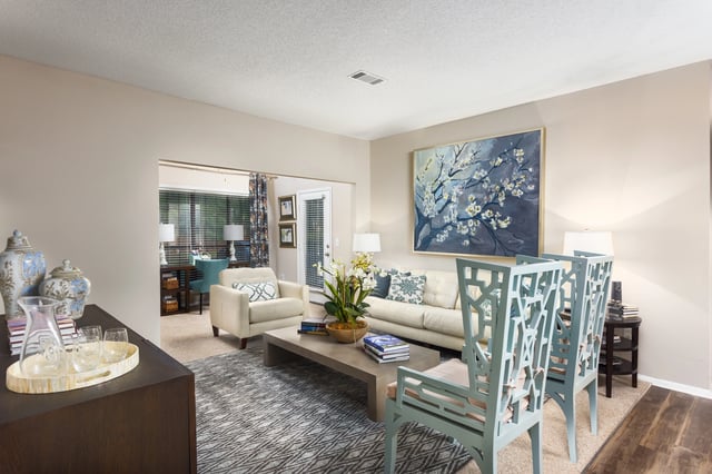 Stylish living room with sofa, armchair, coffee table, and decorative artwork.