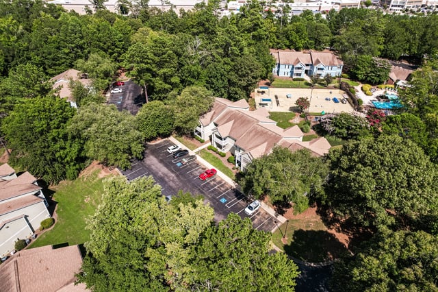 Aerial view of apartment buildings, a swimming pool, and a playground.