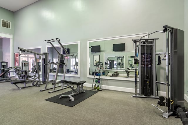 Fitness center with various weight machines and free weights.