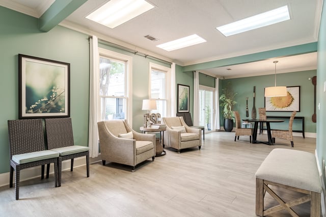 Comfortable seating area with chairs and a bench in a community lounge.