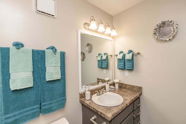 Bathroom vanity with sink, mirror, and towels.